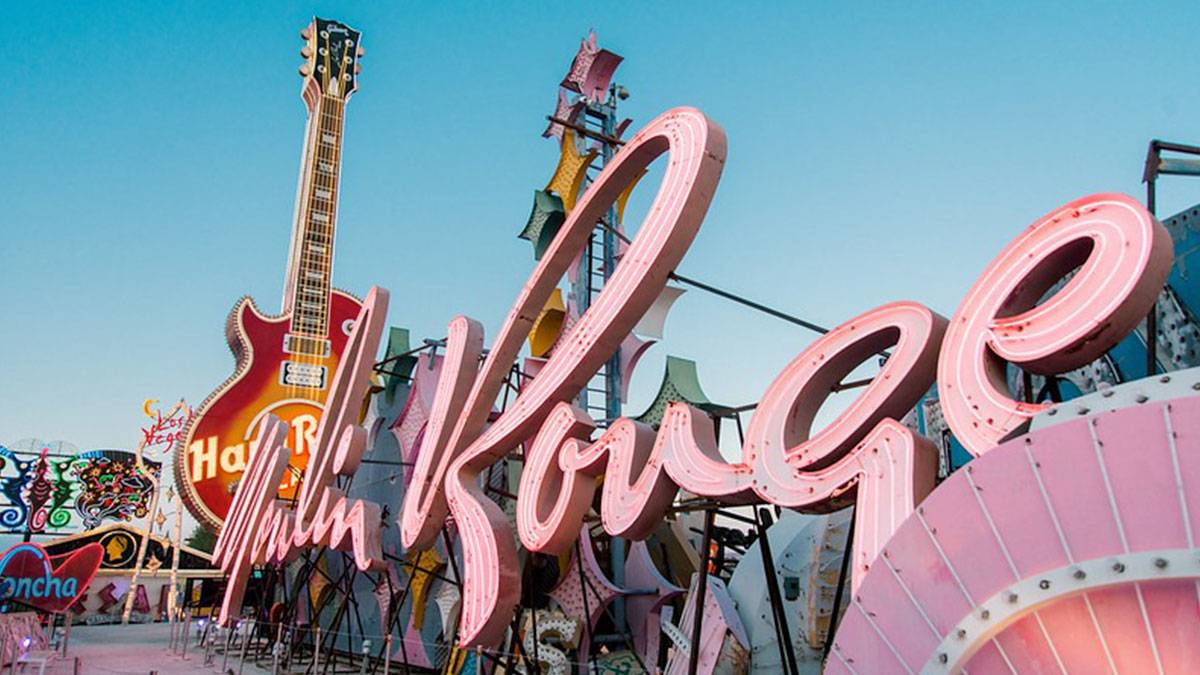 angled shot of neon pink sign of Moulin Rouge Hotel with Hard Rock cafe guitar logo in the background in Las Vegas, Nevada, USA